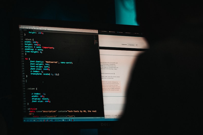 Developer coding on dual monitors